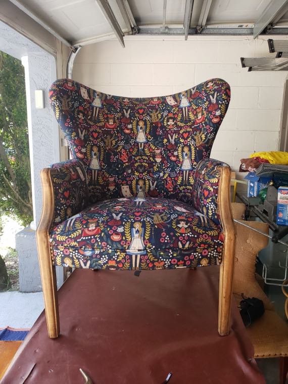Wingback chair reupholstered in a bold printed fabric, in the workshop